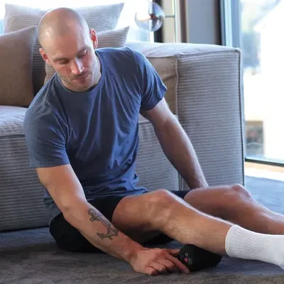 Person som bruker Abilica vibrerende massasjerulle på låret for å myke opp musklene