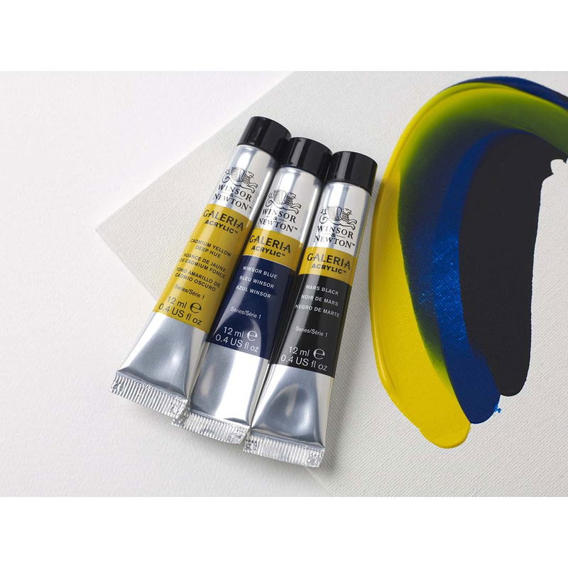 Tre tuber Winsor & Newton Galeria Acrylic 12 ml med färgprov på duk. Färgerna är gul, blå och svart.