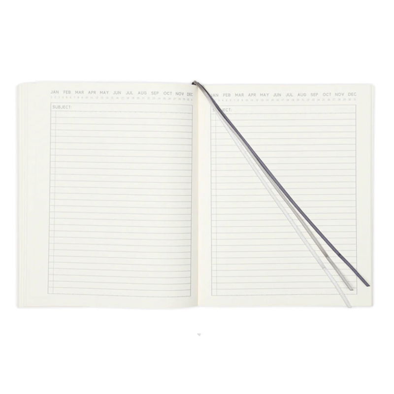 Insida av Standard Issue skrivbok med tre tygband som sidmarkörer och linjerade blad.