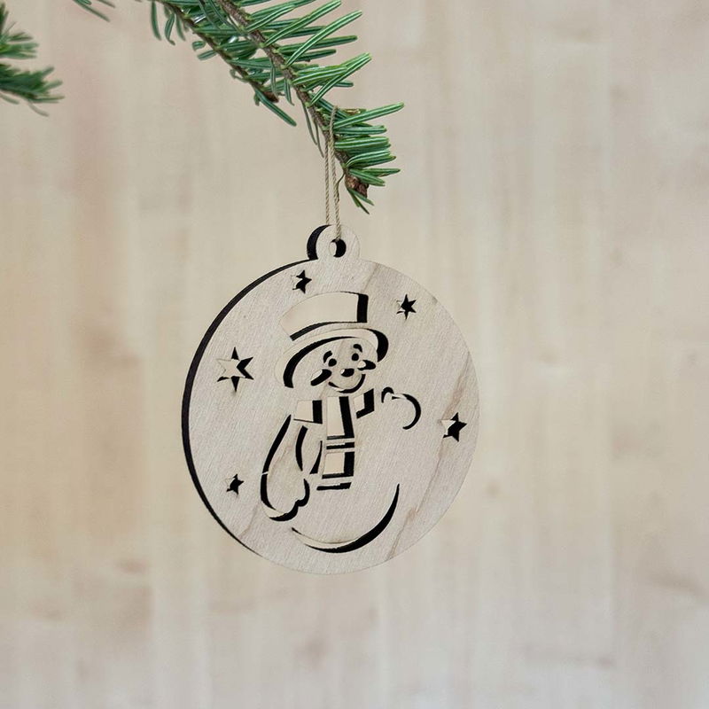 Julgranshänge Snögubbe i kula, trädekoration för vinter och jul Trähänge i form av en snögubbe inuti en rund kula med stjärnor, hängandes i gran med naturligt träutseende.