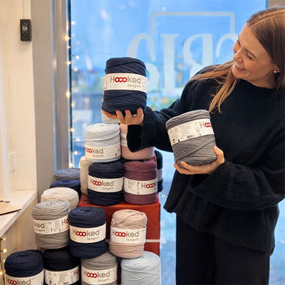 Emelie på Cria i Linköping håller upp T-shirtgarn från Hooked