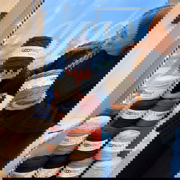 Emelie på Cria i Linköping håller upp T-shirtgarn från Hooked