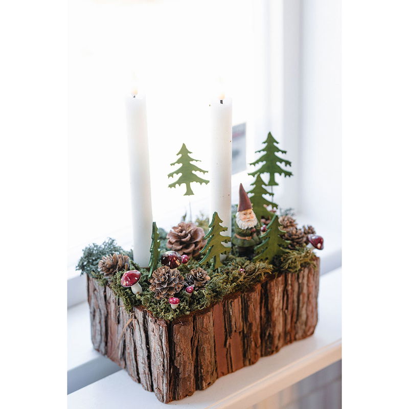 Adventsdekoration med ljus, flugsvampar, en tomte, mossa och kottar