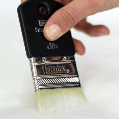 Pensel applicerar Liquitex Clear Gesso på underlag för att skapa en jämn, absorberande yta