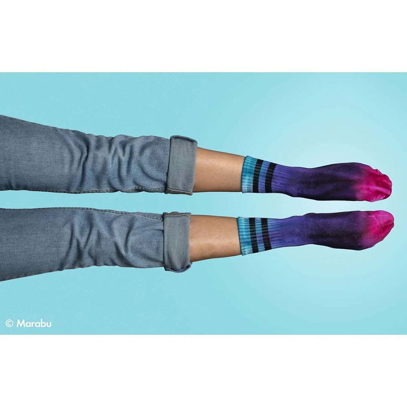 Ben i jeans och tie-dye strumpor i starka blå, lila och rosa färger mot blå bakgrund.