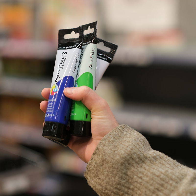 Hand som håller tre stycken System3 i Crias butik