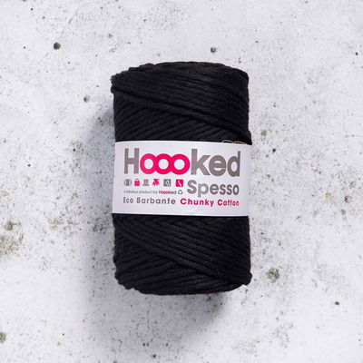 Svart Hoooked Spesso Chunky Cotton 500g garnnystan på betongbakgrund