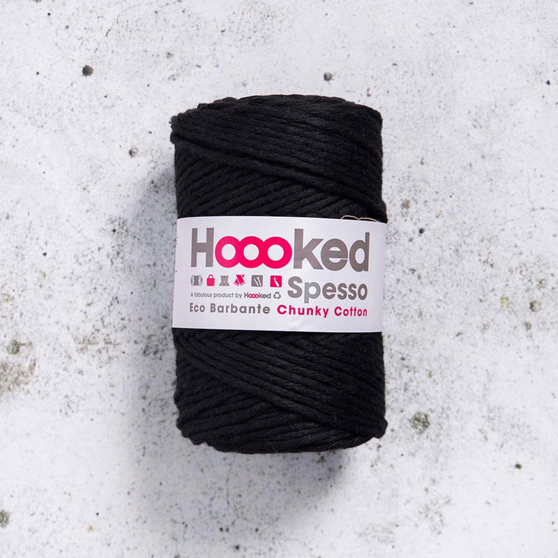 Svart Hoooked Spesso Chunky Cotton 500g garnnystan på betongbakgrund