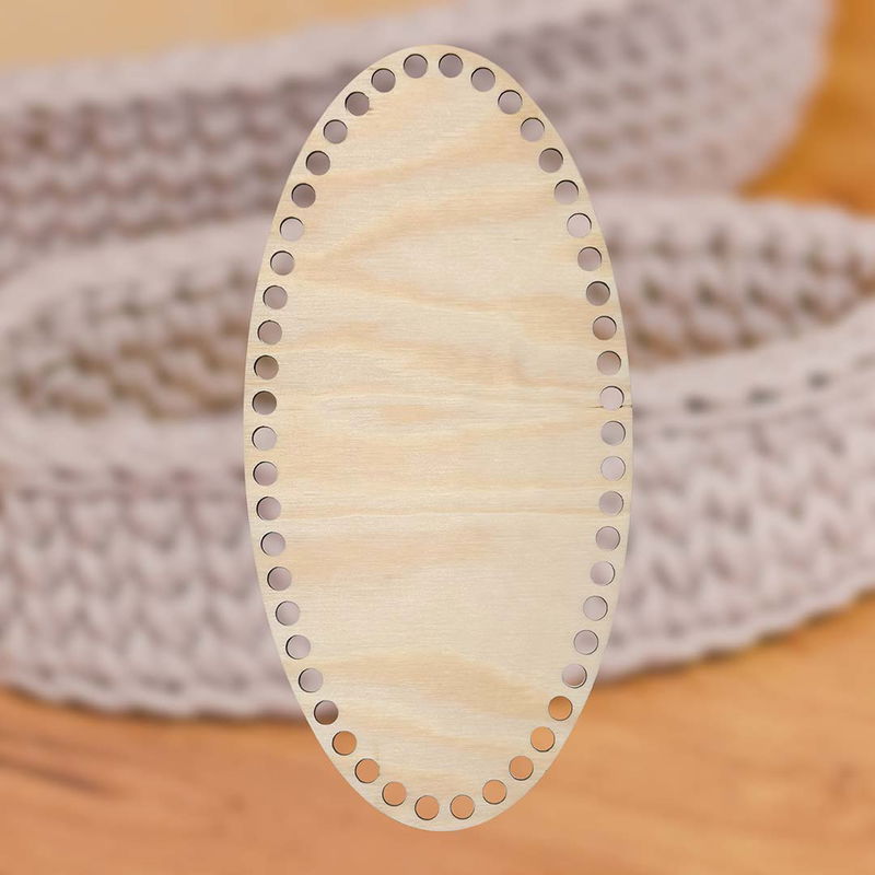Smal oval korgbotten, dia. 15x30 cm, i ljus furuplywood med 9 mm hål, placerad mot en bakgrund en virkad korg