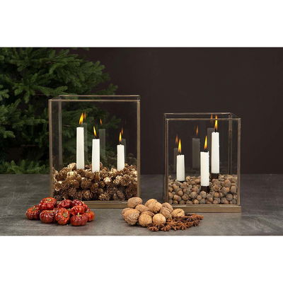 Glaslykta dekorerad med ekollon, kottar och ljus