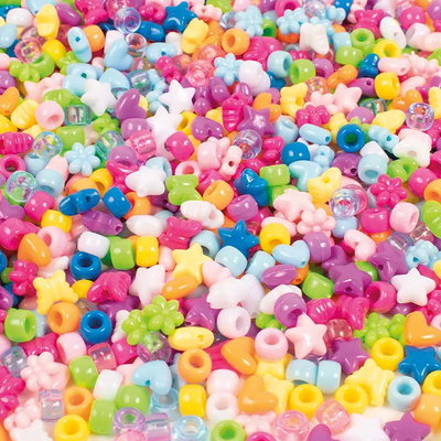 Närbild av pärlmix med hjärtan, blommor, stjärnor, fjärilar och pony beads i olika färger