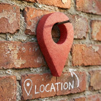 Kartpin av frigolit, rödmålad, mot en tegelvägg