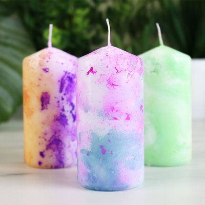 Marmorerade ljus i lila, rosa, blått och grönt gjorda med DIY Candle Marbling Kit