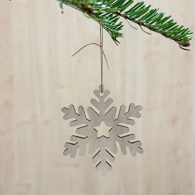 Julgranshänge Snöflinga i björkplywood, elegant dekoration för jul och vinter Trähänge i form av en snöflinga med utskuren stjärna i mitten, hängandes i en grön julgran.