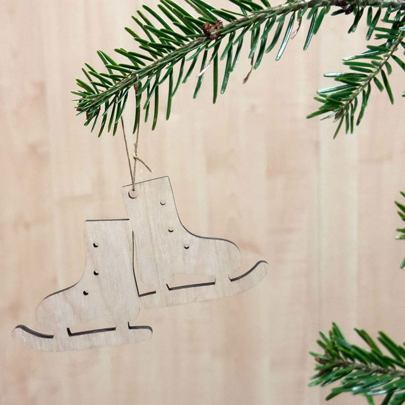 Julgranshänge Skridskor i trä, enkel och stilren dekoration Trähänge i form av skridskor i naturlig björkplywood, upphängt i grankvist, perfekt för målning eller naturlig julstil.