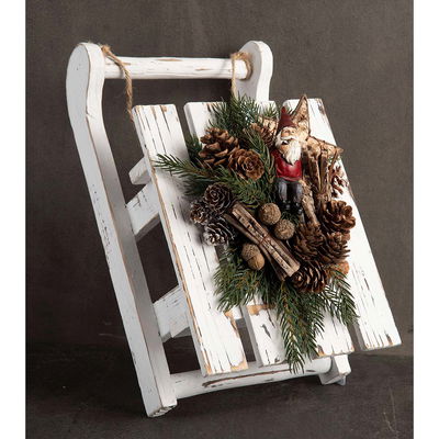 Vit träkälke dekorerad med ekollon, granris och kottar