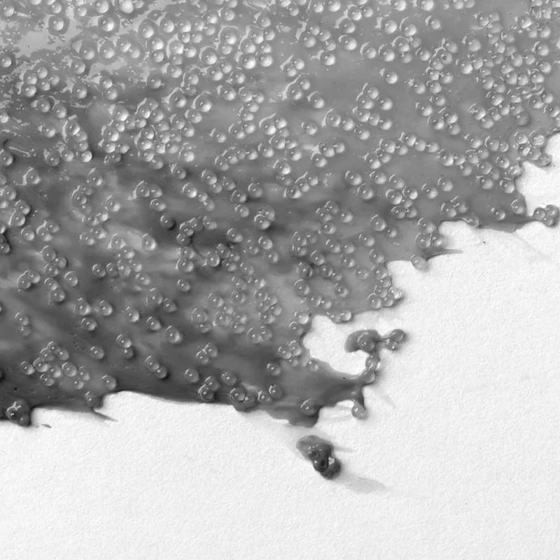 Bubblig, reflekterande textur av Liquitex Glass Beads applicerad på papper