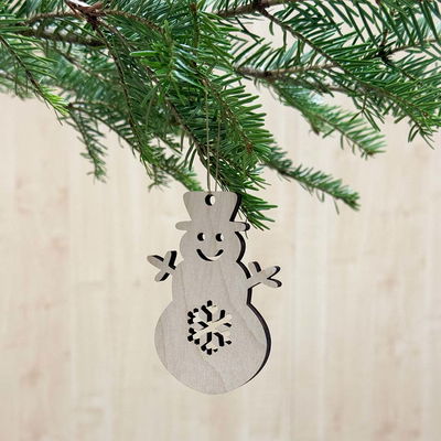 Snögubbe i trä, naturligt julhänge att dekorera eller lämna obehandlad Julhänge i form av en snögubbe med utskuren snöflinga i magen, tillverkad i naturfärgat trä och hängande i gran.