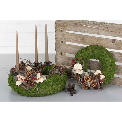 Gröna kransar dekorerade med röda björnbär, kottar och naturmaterial