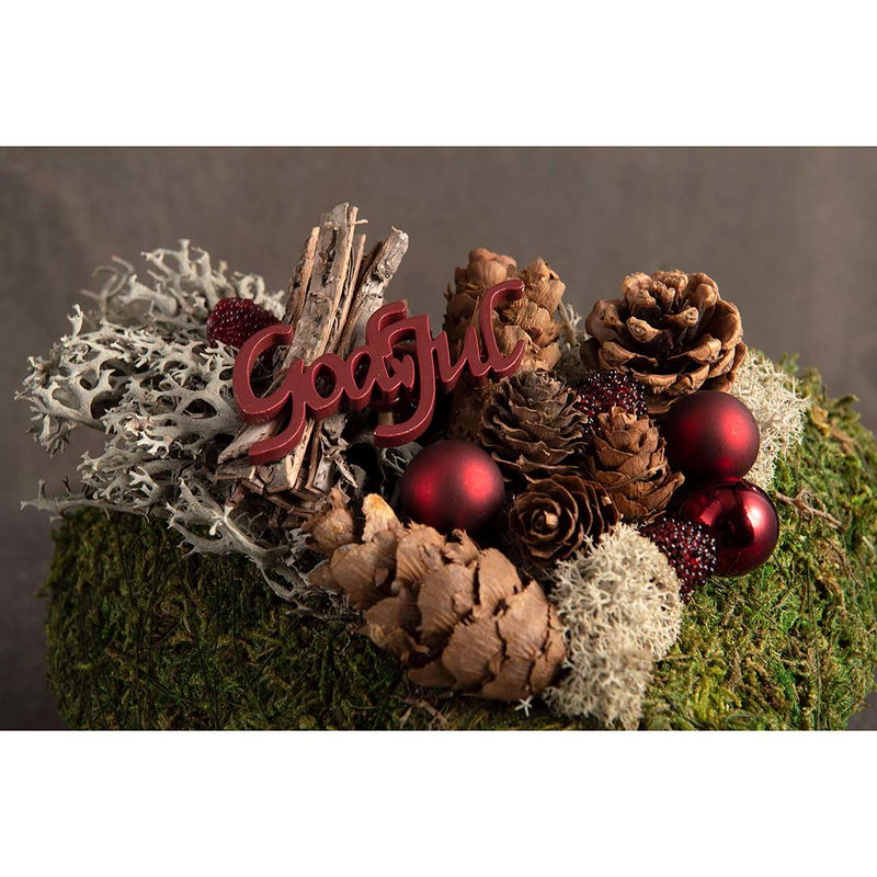 Grön krans dekorerad med röda björnbär, kottar och juldekoration