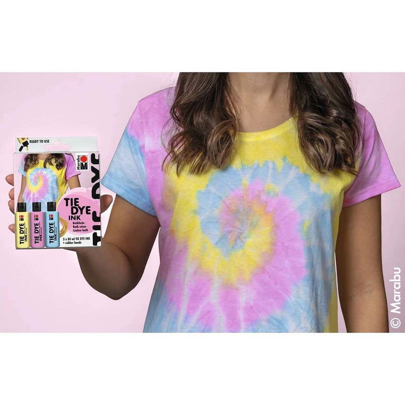 Kvinna i pastellfärgad tie-dye t-shirt håller Marabu Tie Dye Ink Set Pastel med tre x 80 ml.