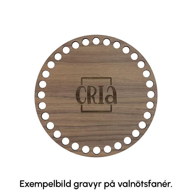 Exempelbild på hur gravyr ser ut på korgbottnar av valnötsfanér. På denna korgbotten är Crias logga graverad
