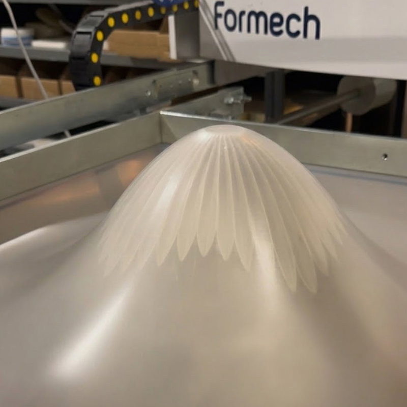 Vakuumformningsmaskin som avformar ett högt objekt