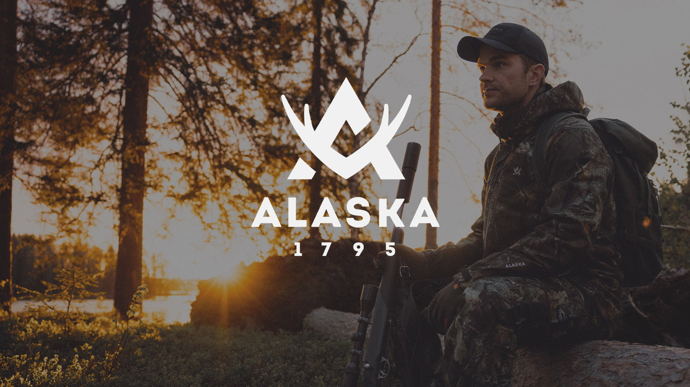Bild med Alaska logotyp och bakgrund med modell som bär Alaska jaktkläder