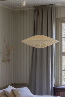 Stor, beige taklampa ovanför matbord