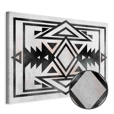 Schuin productaanzicht van Ethnic pattern wide. Het motief loopt door over de randen van het canvas. Een ronde detailopname toont het reliëf van het geloppervlak.