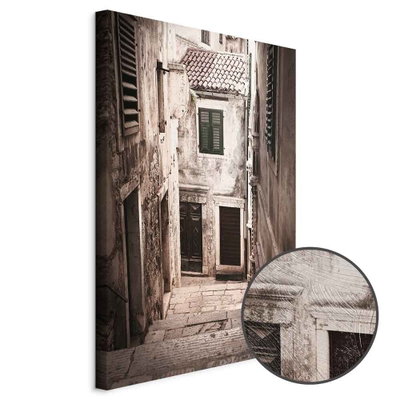 Schuin productaanzicht van Retro alley. Het motief loopt door over de randen van het canvas. Een ronde detailopname toont het reliëf van het geloppervlak.