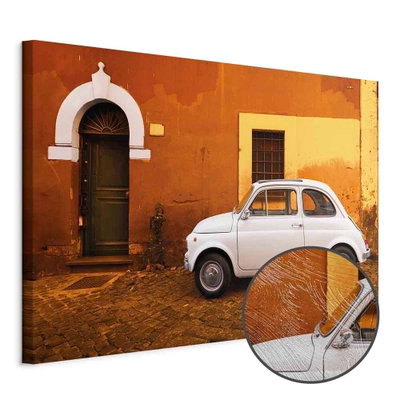 Schuin productaanzicht van Italian street wide. Het motief loopt door over de randen van het canvas. Een ronde detailopname toont het reliëf van het geloppervlak.