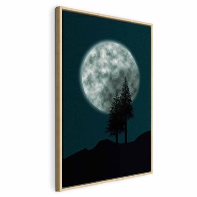 Beautiful full moon vertical – naturfärgad ram. En stor ljus fullmåne hänger ovan mörka kullar och två smala barrträd mot en djup blågrön himmel.