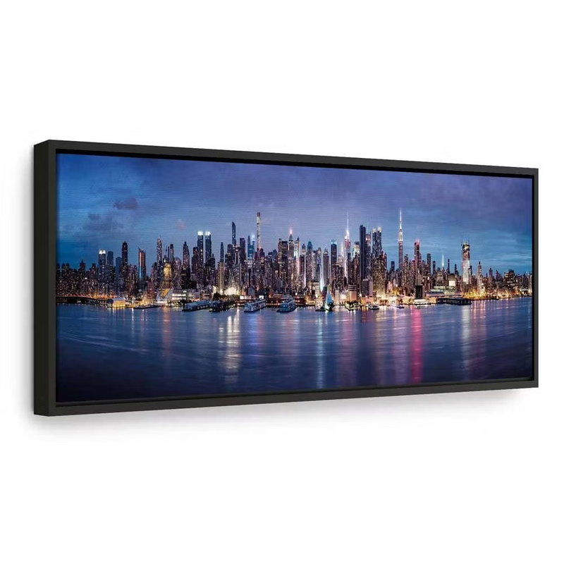 New york nights – svart ram. Många upplysta skyskrapor speglas i blått vatten under en mörknande himmel.