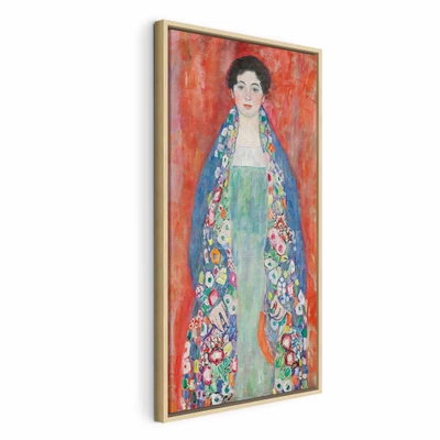 Gustav klimt portrait of – naturfärgad ram. En mörkhårig kvinna i en lång, mönstrad och färgrik dräkt står mot en kraftigt röd bakgrund.