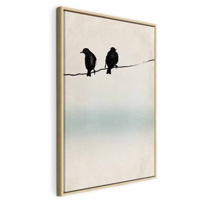 Frozen sparrows vertical – naturfärgad ram. Två mörka fågelsilhuetter sitter på en smal tråd framför en ljus bakgrund med ett mjukt turkost fält.