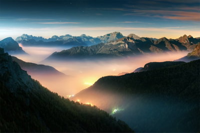 Mountain breath wide second – motivvy. Mörka bergsryggar omger en dal med varm, gyllene dimma och en ljus horisont.