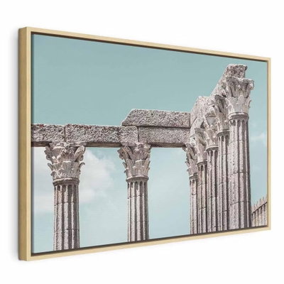 Pillars of history wide – naturfärgad ram. En rad ljusa stenpelare med utsmyckade kapitäl står mot en blekt turkos himmel.