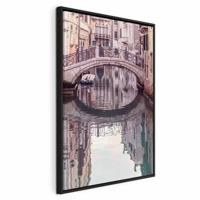 Noon in venice vertical – svart ram. En liten stenbro och täta husfasader speglas i en lugn kanal i mjuka rosa och grå toner.