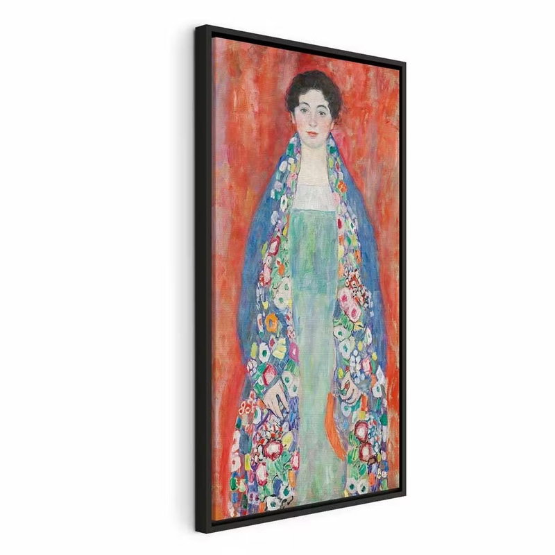 Gustav klimt portrait of – svart ram. En mörkhårig kvinna i en lång, mönstrad och färgrik dräkt står mot en kraftigt röd bakgrund.