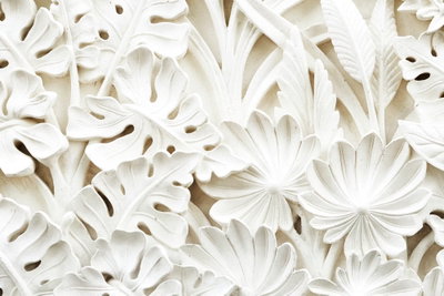 Ceramic leaves wide – motivvy. Täta vita blad- och blomformer med tydliga skuggor bildar ett tryckt mönster med skenbar relief.