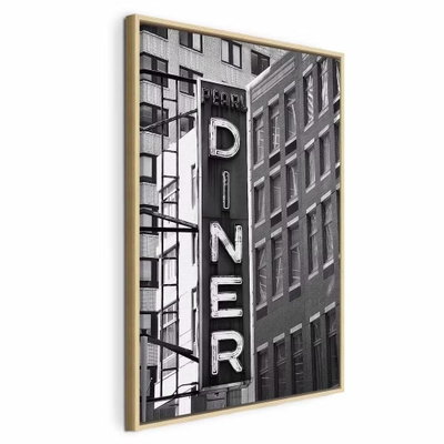 New york neon sign vertical – naturfärgad ram. En hög DINER-skylt hänger mellan täta husfasader i en svartvit gatubild.
