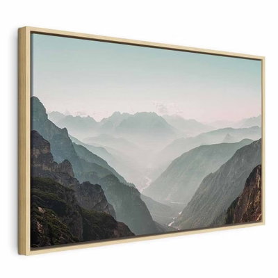 Mountain horizon wide – naturfärgad ram. Mjuka lager av grågröna berg leder mot en disig, nästan vit horisont under en blek himmel.