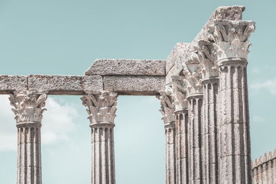 Pillars of history wide – motivvy. En rad ljusa stenpelare med utsmyckade kapitäl står mot en blekt turkos himmel.