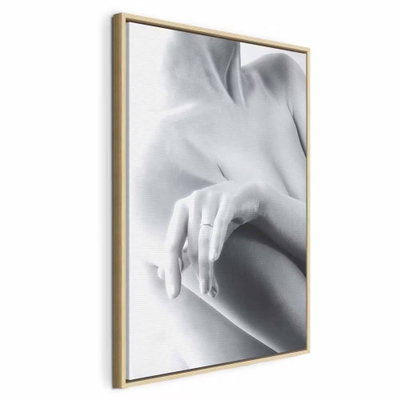 Feminine delicacy vertical – naturfärgad ram. En ljus hand vilar mot en naken axel i ett mjukt beskuret svartvitt fotografi.