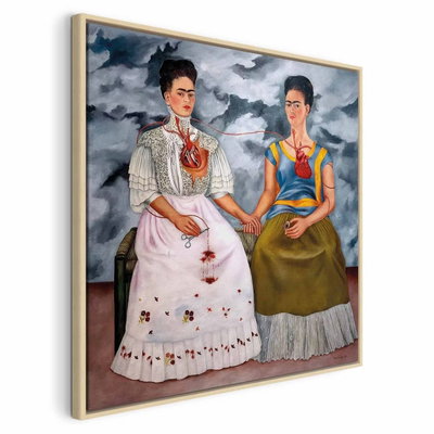 Frida kahlo the two fridas – naturfärgad ram. Två mörkhåriga kvinnor sitter hand i hand i vit respektive grön klädsel under en mörk, molnig himmel.