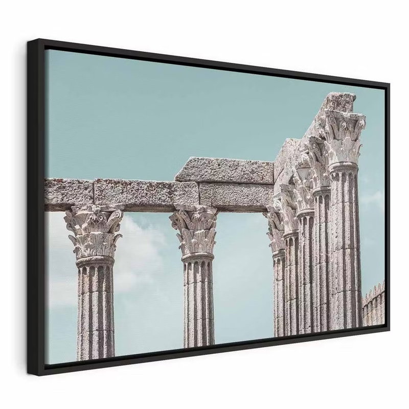 Pillars of history wide – svart ram. En rad ljusa stenpelare med utsmyckade kapitäl står mot en blekt turkos himmel.