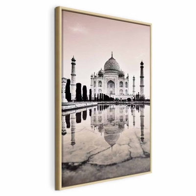 Taj mahal vertical – naturfärgad ram. Den ljusa byggnaden och dess minareter speglas i vatten under en blekt rosa himmel.