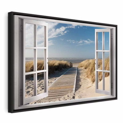 Window view of the beach – svart ram. Ett tryckt öppet fönster visar en träspång genom sand och strandgräs mot havet.