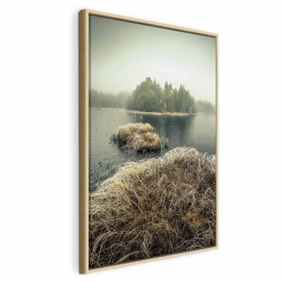 Autumn in the wetlands – naturfärgad ram. Små bruna gräsöar ligger i stilla vatten framför en mörk trädridå under en ljust grönaktig dimhimmel.